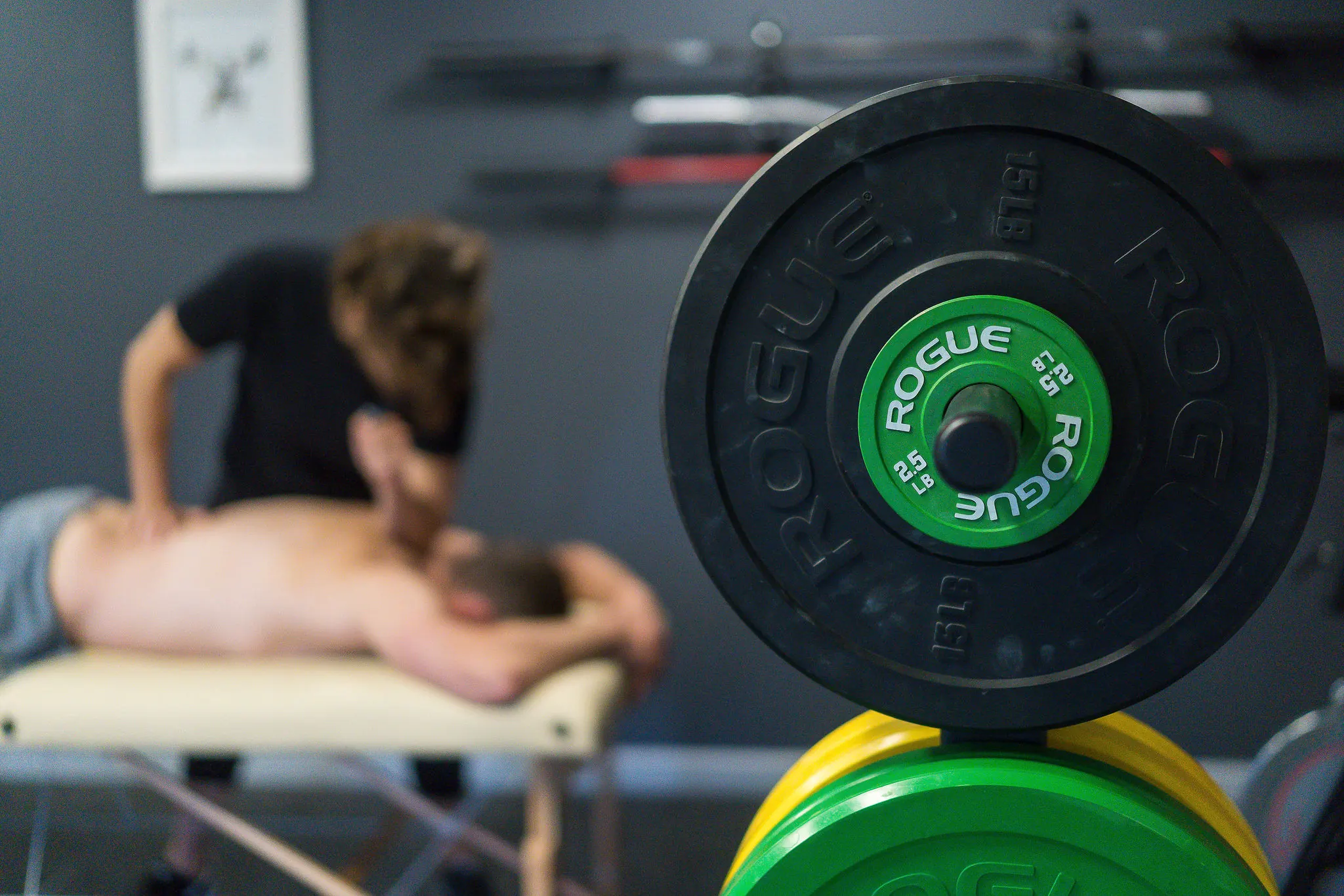 Massage therapist working with client in professional gym setting